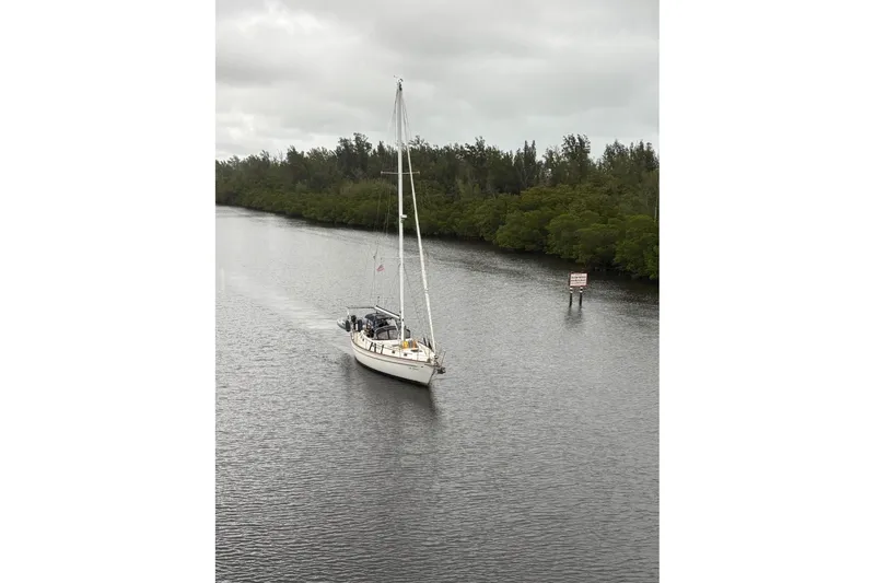 Slide: The Image of 1981 Gulfstar 44 Mk II Center Cockpit Sloop docked with inflatable dinghy, under blue sky. - 2