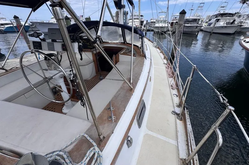 Slide: The Image of 1981 Gulfstar 44 Mk II Center Cockpit Sloop docked, showcasing spacious deck and steering wheel. - 32