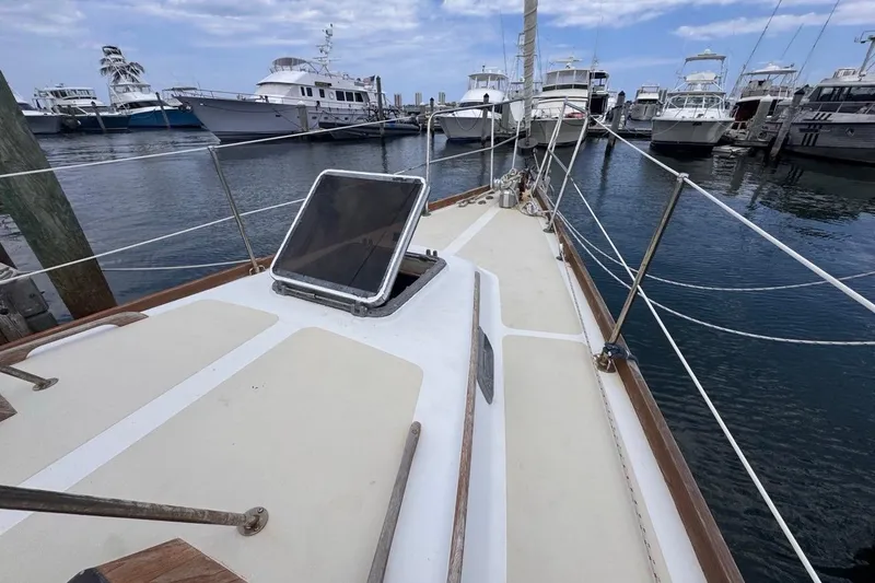 Slide: The Image of 1981 Gulfstar 44 Mk II Center Cockpit Sloop docked, showcasing deck and marina view. - 38