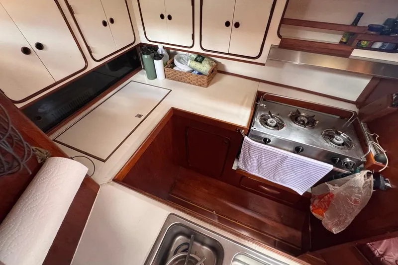 Slide: The Image of 1981 Gulfstar 44 Mk II Center Cockpit Sloop galley with stove, sink, and storage cabinets. - 49