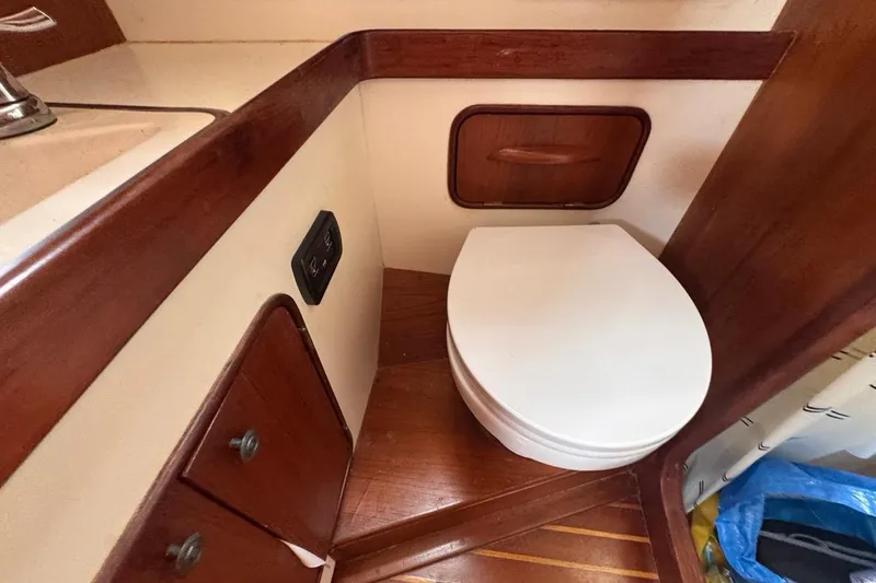 Slide: The Image of 1981 Gulfstar 44 Mk II Center Cockpit Sloop bathroom with wooden cabinetry and toilet. - 67