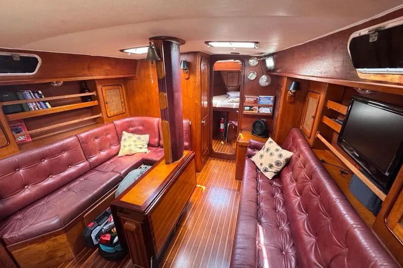 Slide: The Image of Interior of 1981 Gulfstar 44 Mk II Sloop with wood paneling and red leather seating. - 72