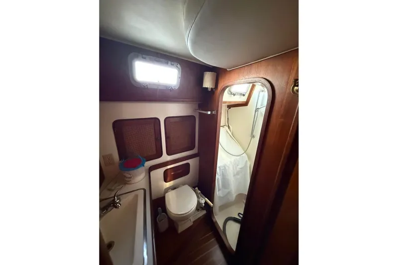 Slide: The Image of Interior of 1981 Gulfstar 44 Mk II Sloop, featuring a compact bathroom with wooden accents. - 12