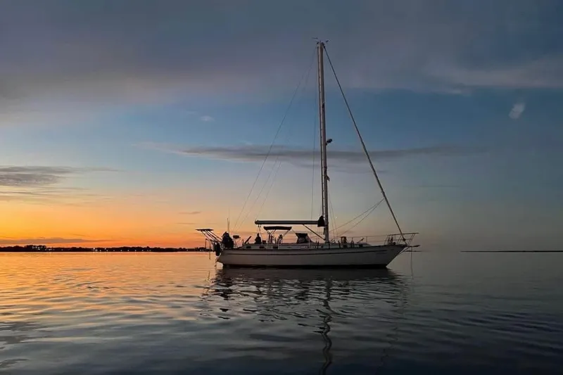 Slide: The Image of 1981 Gulfstar 44 Mk II Center Cockpit Sloop sailing at sunset on calm waters. - 4