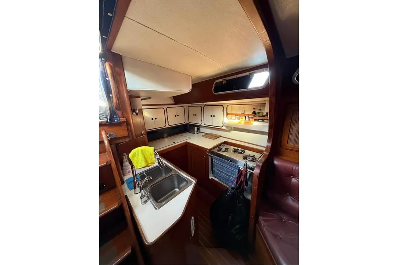 Slide: The Image of Interior of 1981 Gulfstar 44 Mk II Sloop, featuring a compact kitchen with wooden cabinetry. - 6