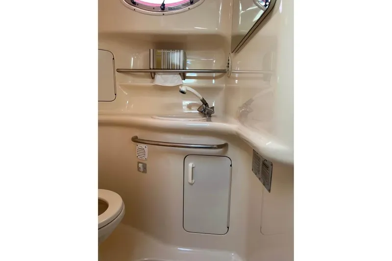 Slide: The Image of 1997 Sea Ray Sundancer 330 bathroom with sink, storage, and porthole window. - 10