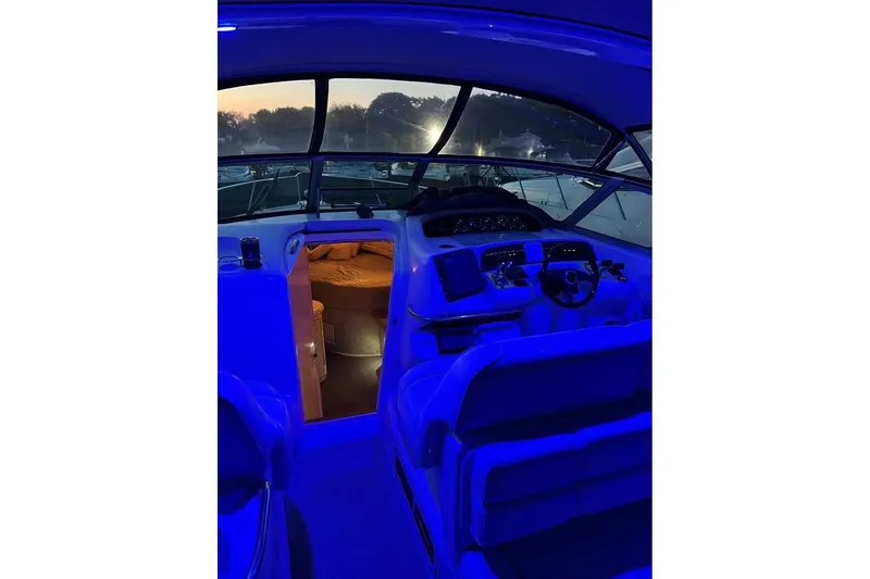 Slide: The Image of 1997 Sea Ray Sundancer 330 cockpit with blue lighting and cabin view at sunset. - 12