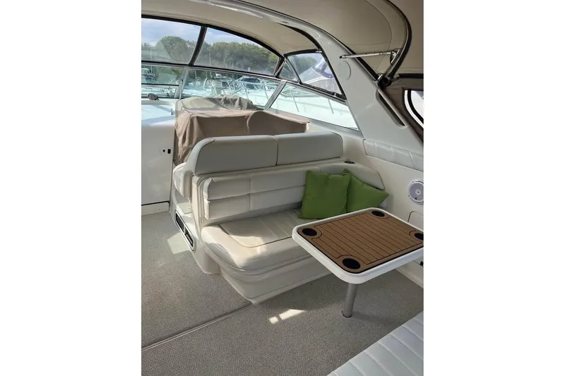 Slide: The Image of 1997 Sea Ray Sundancer 330 interior with seating, table, and green cushions. - 4