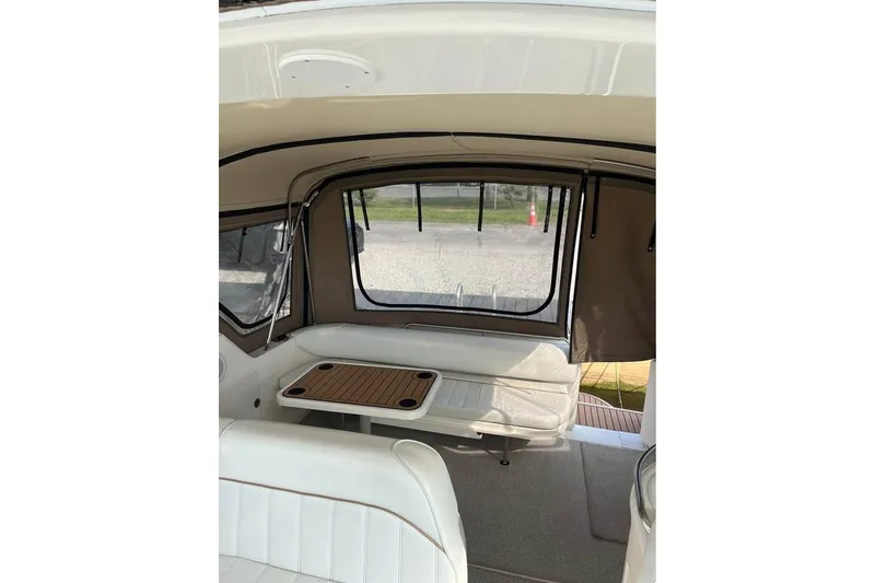 Slide: The Image of Interior of 1997 Sea Ray Sundancer 330, featuring seating and a table in a covered area. - 6