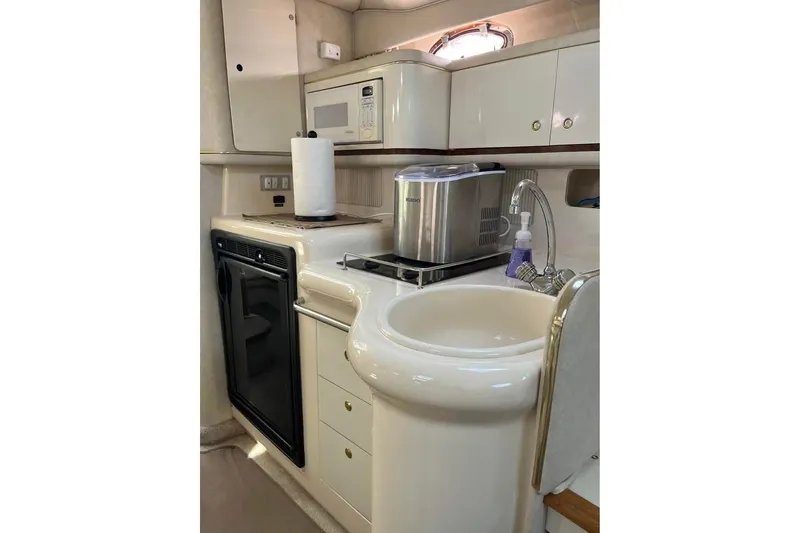Slide: The Image of 1997 Sea Ray Sundancer 330 yacht kitchen with sink, microwave, and compact appliances. - 9