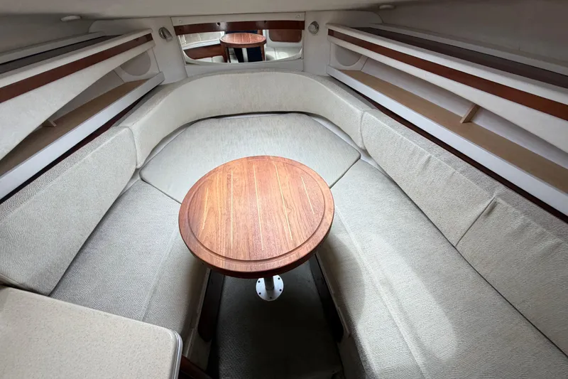 Slide: The Image of Interior of 2008 Sea Ray 270 Amberjack boat with cozy seating and wooden table. - 18