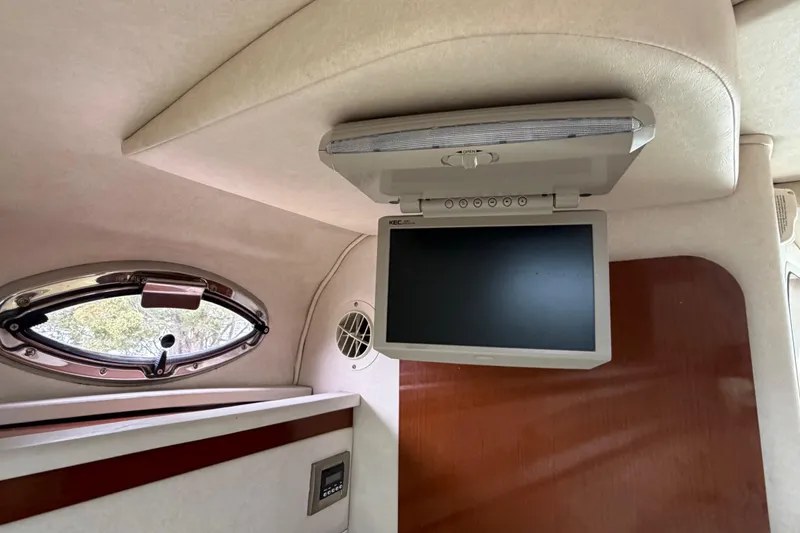 Slide: The Image of 2008 Sea Ray 270 Amberjack cabin interior with ceiling-mounted TV screen. - 22