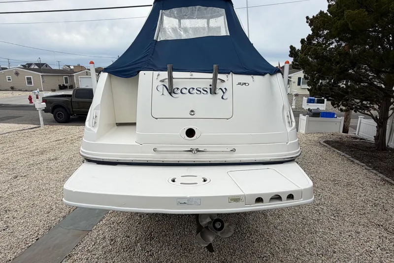 Slide: The Image of 2008 Sea Ray 270 Amberjack boat with blue canopy, parked on gravel. - 6