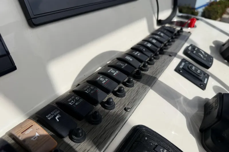 Slide: The Image of Control panel of a 2020 Sea Chaser 27 HFC CC boat with labeled switches. - 31