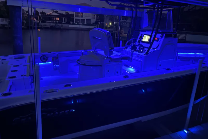 Slide: The Image of 2020 Sea Chaser 27 HFC CC boat illuminated with blue LED lights at night. - 45