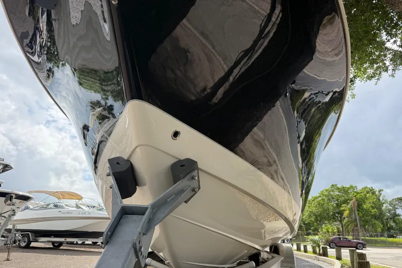 Slide: The Image of 2020 Sea Chaser 27 HFC CC boat on trailer, glossy black hull, outdoor setting. - 6