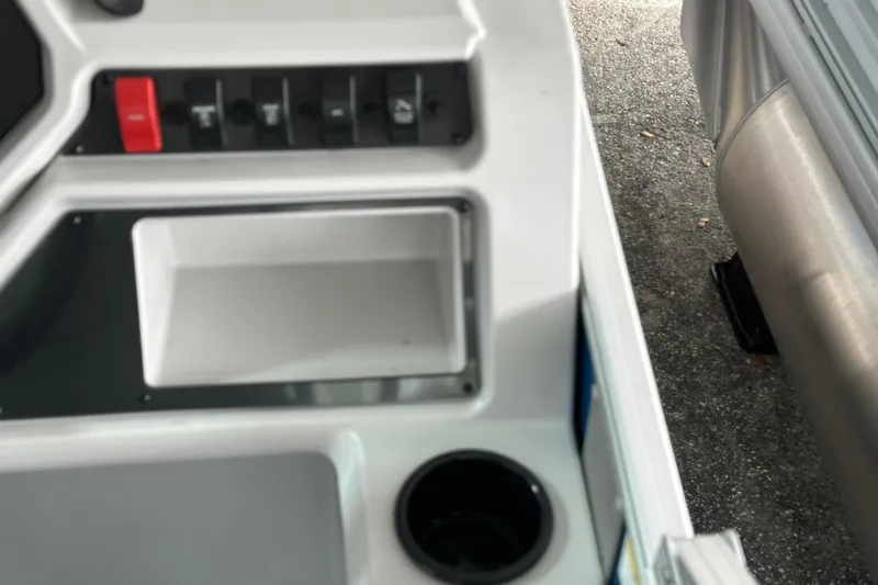 Slide: The Image of Control panel of 2026 Sweetwater EX2086SFLX boat with switches and cup holder. - 13