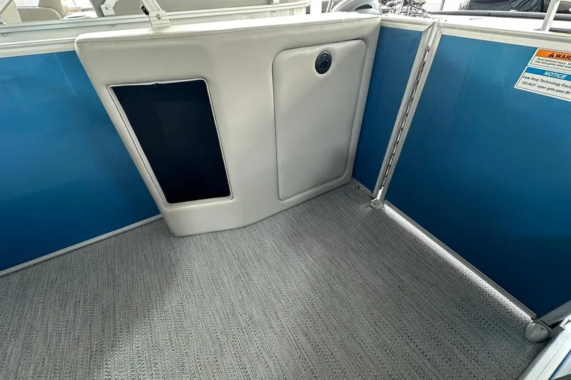 Slide: The Image of Interior of 2026 Sweetwater EX2086SFLX boat with blue paneling and carpeted floor. - 17