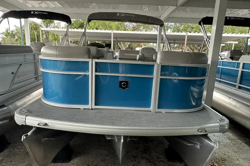 Slide: The Image of 2026 Sweetwater EX2086SFLX pontoon boat with blue exterior under a canopy. - 2