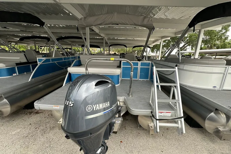 Slide: The Image of 2026 Sweetwater EX2086SFLX pontoon boat with Yamaha 115 engine, docked under shelter. - 23