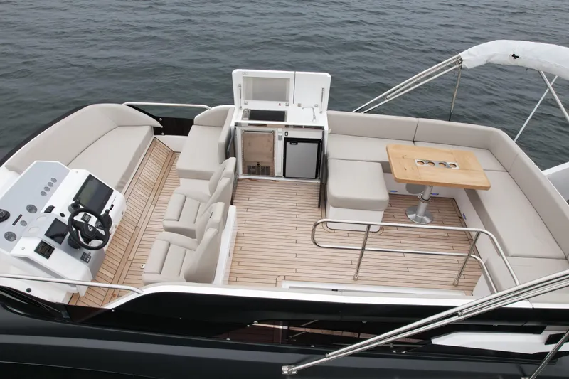 Slide: The Image of 2024 Fairline Squadron 50 yacht deck with seating, table, and helm, overlooking the water. - 60