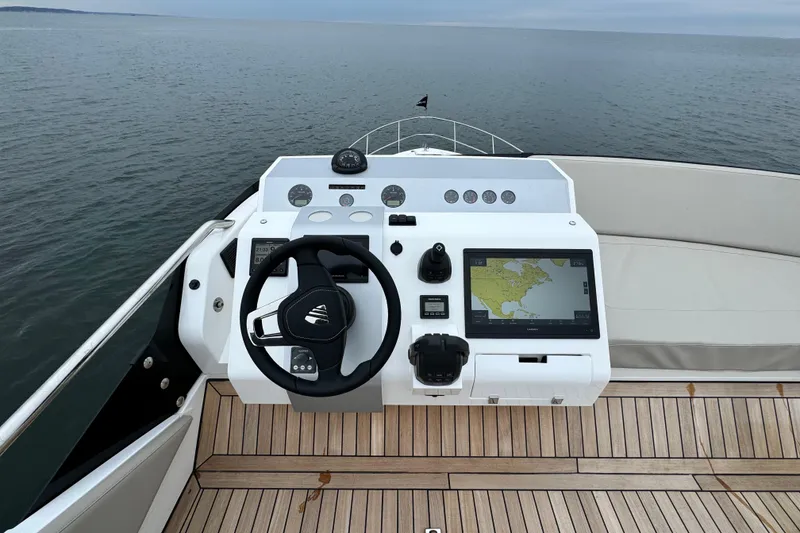 Slide: The Image of 2024 Fairline Squadron 50 yacht helm with navigation display on open water. - 62