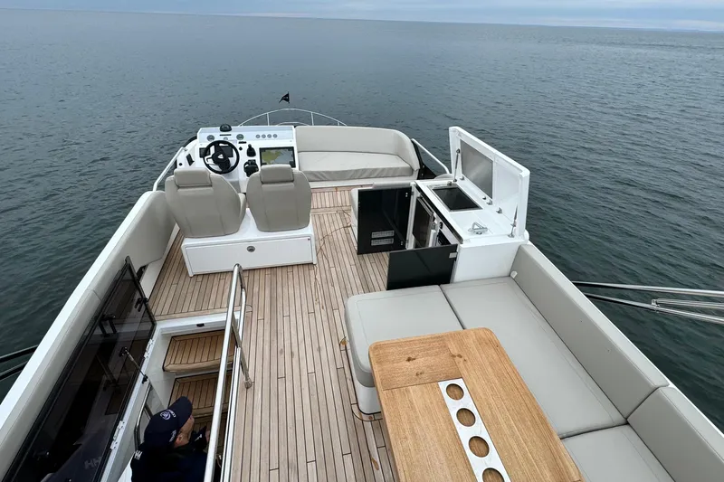 Slide: The Image of 2024 Fairline Squadron 50 yacht deck with seating, helm, and ocean view. - 65