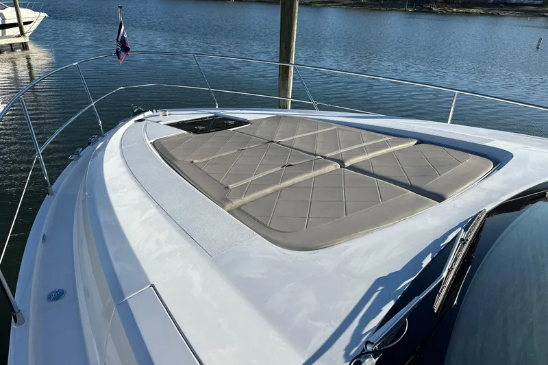 Slide: The Image of 2024 Fairline Squadron 50 yacht with sunbathing cushions on deck, docked by the water. - 68