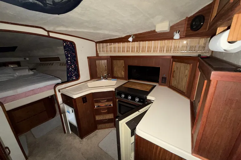 Slide: The Image of Interior of 1986 Sea Ray 340 Sundancer boat with kitchenette and sleeping area. - 15