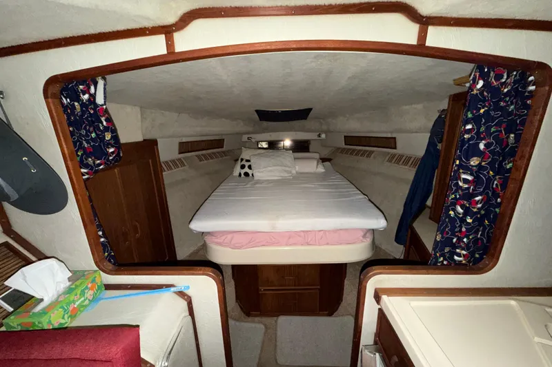 Slide: The Image of Interior cabin of 1986 Sea Ray 340 Sundancer with bed and nautical decor. - 17