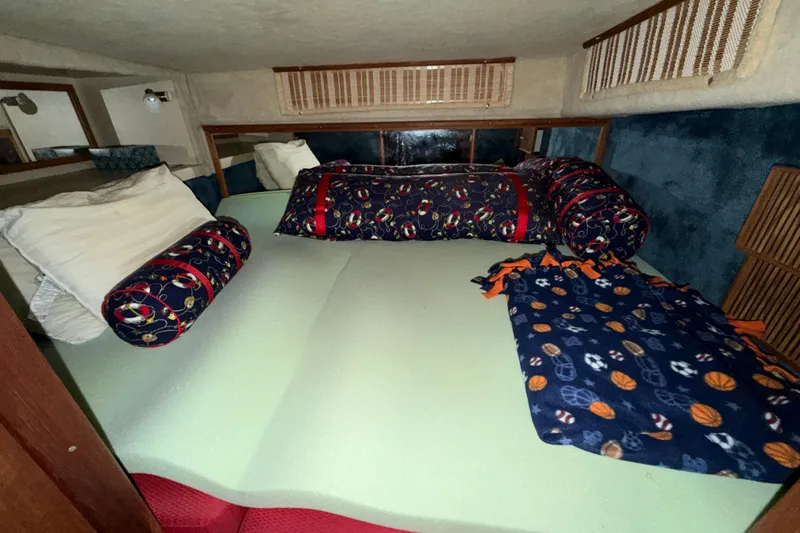Slide: The Image of Cozy cabin interior of 1986 Sea Ray 340 Sundancer with nautical-themed bedding. - 19