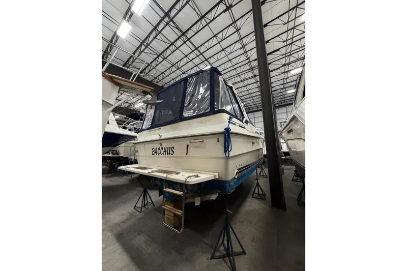 Slide: The Image of 1986 Sea Ray 340 Sundancer boat in storage, rear view with blue canopy. - 2