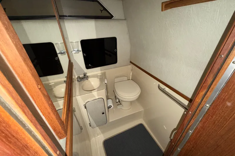 Slide: The Image of 1986 Sea Ray 340 Sundancer boat bathroom with toilet, sink, and mirror. - 20