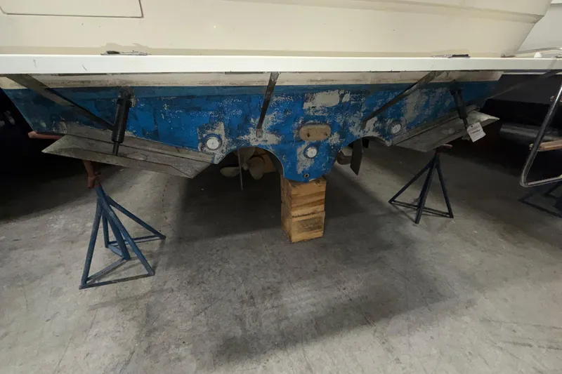 Slide: The Image of 1986 Sea Ray 340 Sundancer boat hull on stands in a garage. - 26