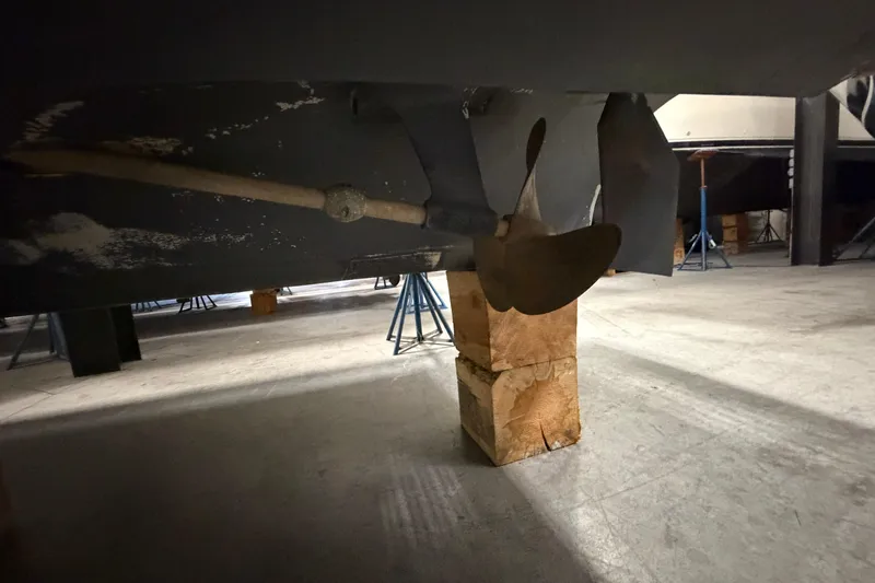 Slide: The Image of 1986 Sea Ray 340 Sundancer propeller and shaft on wooden blocks in a storage facility. - 28