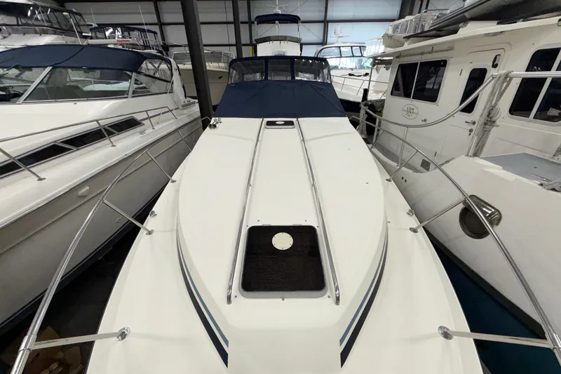 Slide: The Image of 1986 Sea Ray 340 Sundancer yacht docked in a marina, surrounded by other boats. - 4