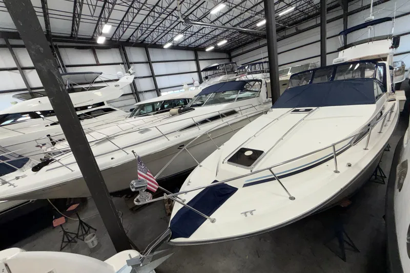 Slide: The Image of 1986 Sea Ray 340 Sundancer yacht in indoor storage, surrounded by other boats. - 5
