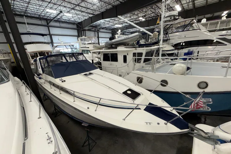 Slide: The Image of 1986 Sea Ray 340 Sundancer yacht in indoor storage, surrounded by other boats. - 6