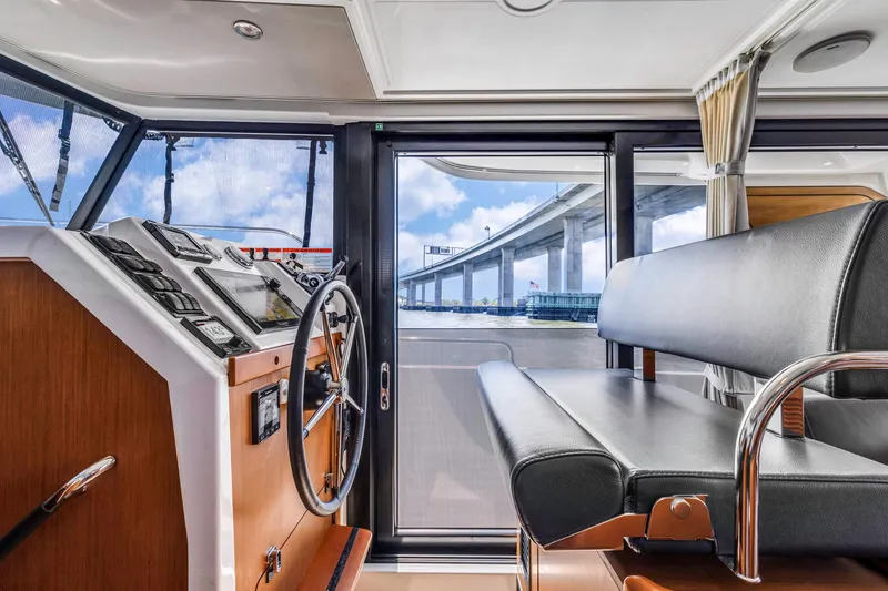 Slide: The Image of Interior view of 2019 Beneteau Swift Trawler 35 helm with bridge in background. - 10
