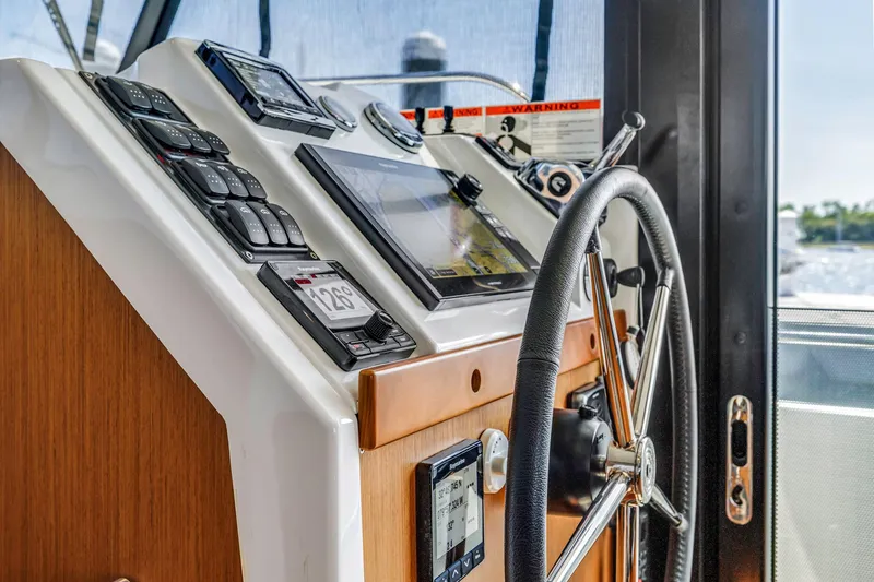 Slide: The Image of Helm of 2019 Beneteau Swift Trawler 35 with navigation instruments and steering wheel. - 11