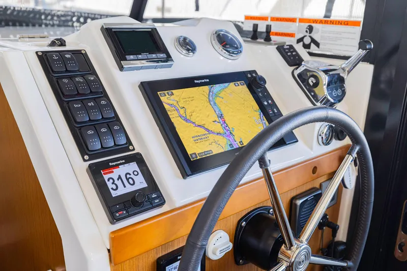 Slide: The Image of 2019 Beneteau Swift Trawler 35 helm with navigation display and controls. - 12