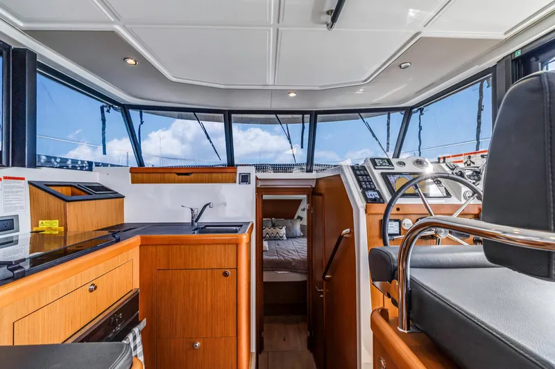 Slide: The Image of Interior of 2019 Beneteau Swift Trawler 35, featuring helm, kitchen, and cabin area. - 14