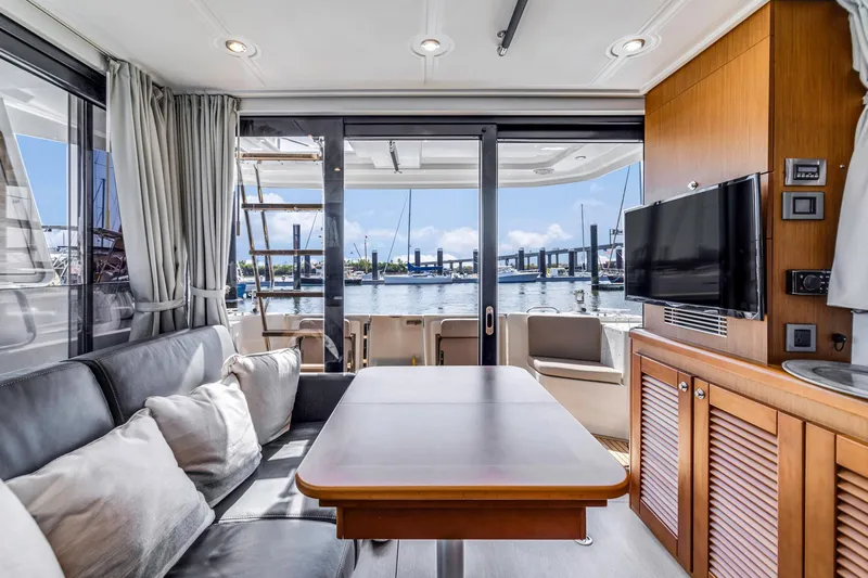 Slide: The Image of Interior of 2019 Beneteau Swift Trawler 35 with marina view, featuring modern furnishings. - 18