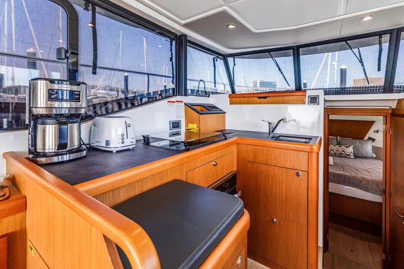 Slide: The Image of 2019 Beneteau Swift Trawler 35 interior kitchen with appliances and cozy cabin view. - 19