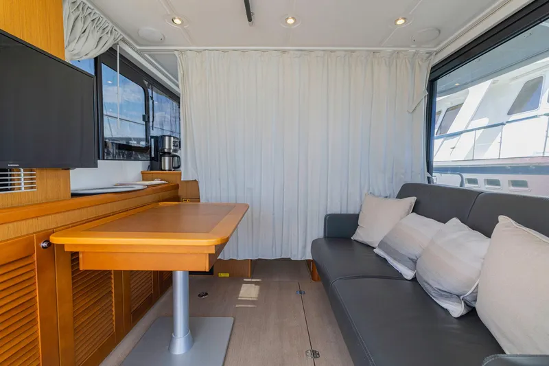Slide: The Image of Interior of 2019 Beneteau Swift Trawler 35 with sofa, table, and TV. - 21