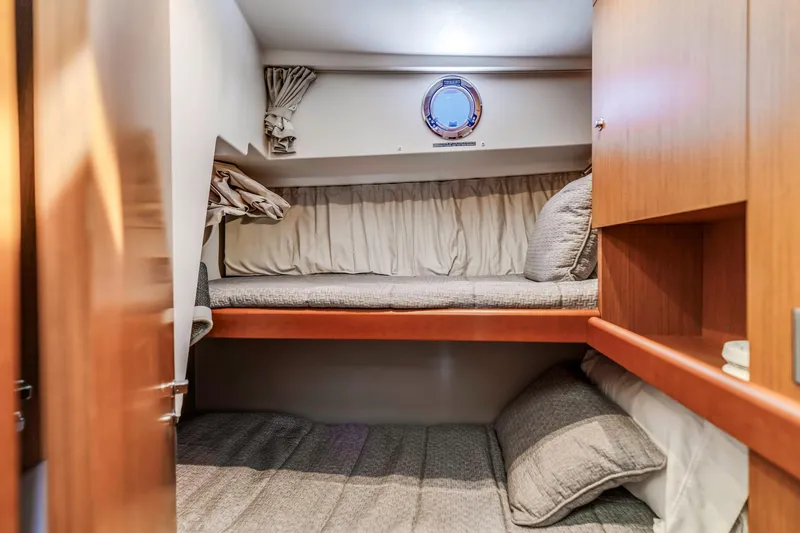 Slide: The Image of Cozy cabin interior of 2019 Beneteau Swift Trawler 35 with bunk beds and porthole. - 25