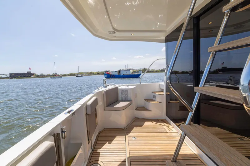 Slide: The Image of 2019 Beneteau Swift Trawler 35 deck with wooden flooring and water view. - 30