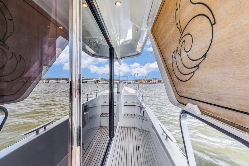 Slide: The Image of 2019 Beneteau Swift Trawler 35 deck view with open hatch and water backdrop. - 32