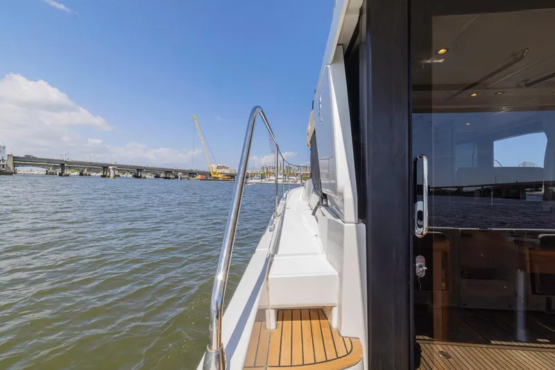 Slide: The Image of 2019 Beneteau Swift Trawler 35 on water near a bridge, sunny day. - 33
