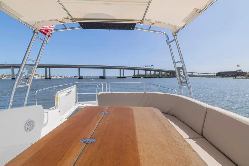 Slide: The Image of 2019 Beneteau Swift Trawler 35 deck view with bridge and water backdrop. - 34